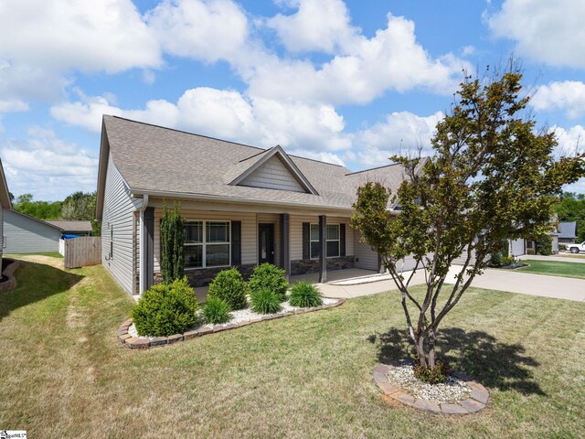 view of front of house featuring fence, a shingled roof, a front yard, and concrete driveway