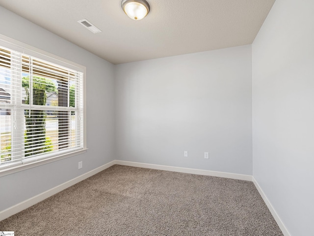 unfurnished room featuring baseboards, carpet flooring, and visible vents