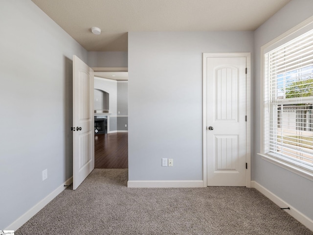 unfurnished bedroom featuring carpet and baseboards