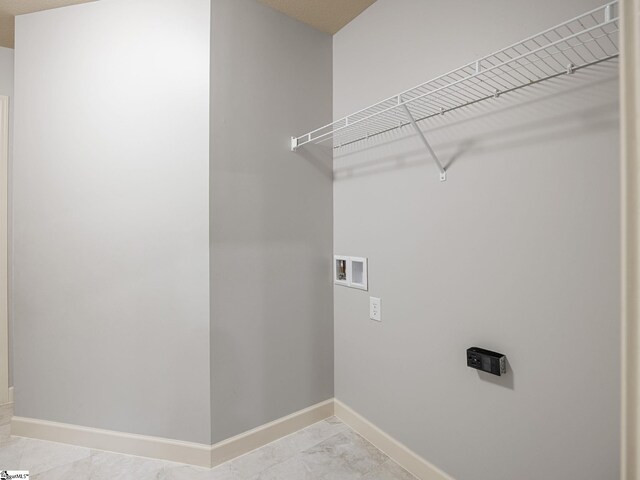 clothes washing area featuring baseboards, laundry area, and washer hookup