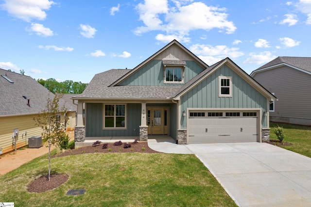craftsman inspired home featuring board and batten siding, driveway, a porch, and a front lawn