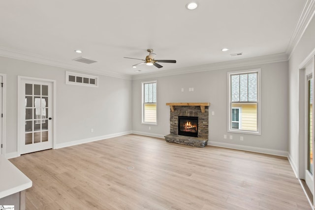 unfurnished living room with plenty of natural light, visible vents, and crown molding
