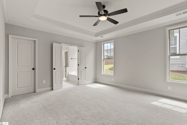 unfurnished bedroom with carpet floors, ornamental molding, visible vents, and a raised ceiling