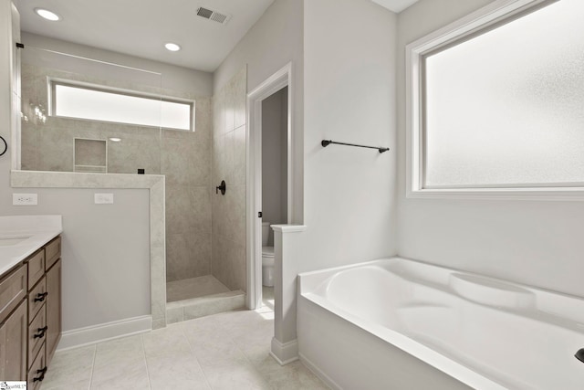 full bath featuring a garden tub, vanity, walk in shower, toilet, and visible vents
