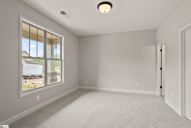empty room featuring baseboards, visible vents, and carpet