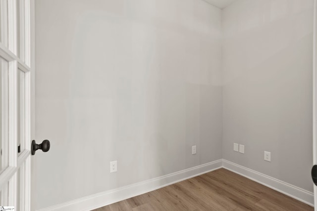 spare room featuring wood finished floors and baseboards