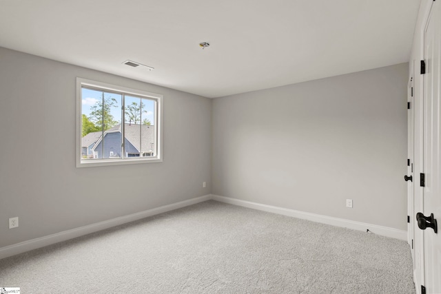 carpeted empty room featuring baseboards and visible vents