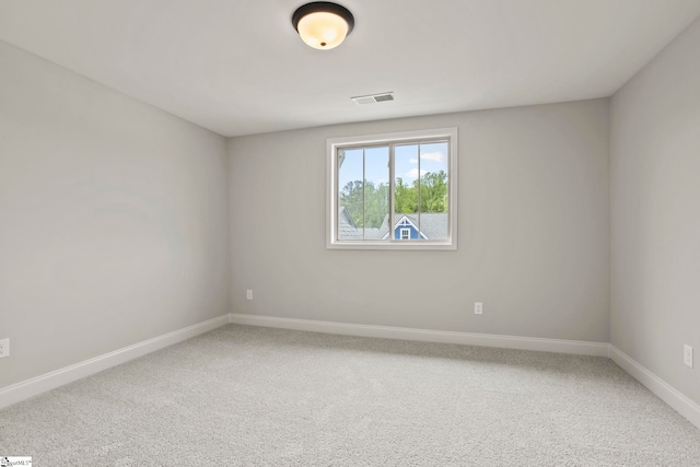 carpeted empty room with visible vents and baseboards