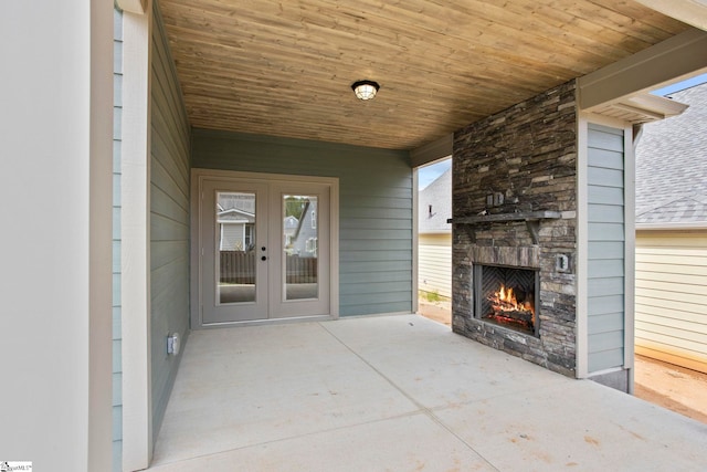 view of patio / terrace with french doors and a lit fireplace