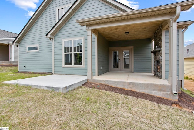 back of house with a lawn and a patio