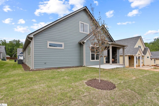 rear view of house with central air condition unit, a yard, and a patio