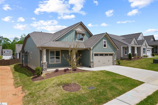 craftsman house featuring concrete driveway, board and batten siding, covered porch, fence, and a front yard