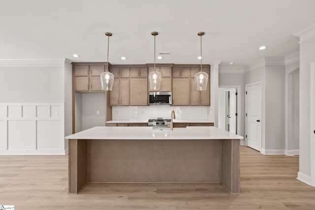 kitchen featuring stainless steel microwave, ornamental molding, a kitchen island with sink, and light countertops