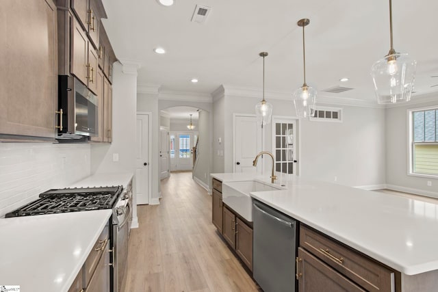 kitchen with plenty of natural light, arched walkways, recessed lighting, and appliances with stainless steel finishes