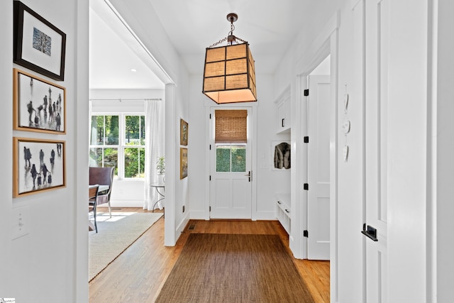 doorway to outside with baseboards and light wood-type flooring