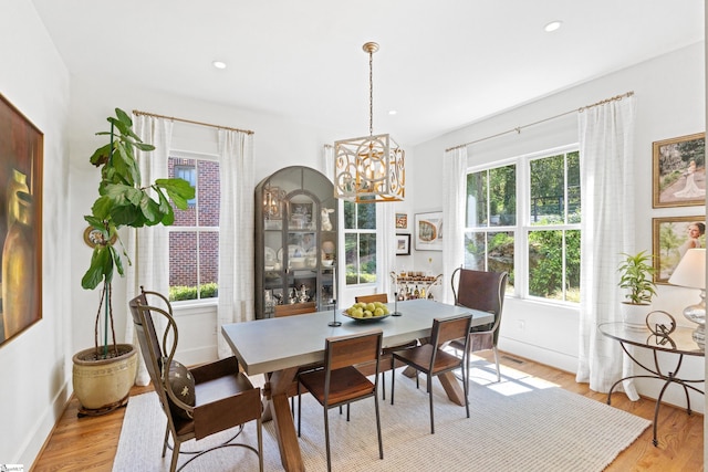 dining space with light wood-style flooring, visible vents, baseboards, recessed lighting, and a chandelier