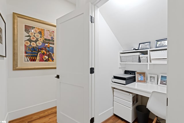 home office featuring light wood-type flooring, baseboards, and built in desk