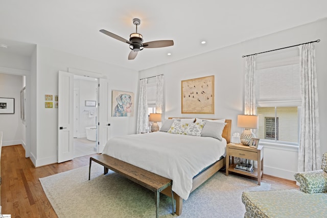 bedroom with baseboards, multiple windows, and light wood-style flooring