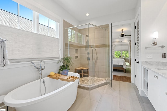 full bathroom featuring a shower stall, a ceiling fan, vanity, a freestanding bath, and tile patterned flooring