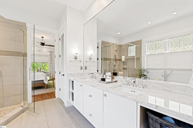 full bath featuring double vanity, a stall shower, ceiling fan, and a sink