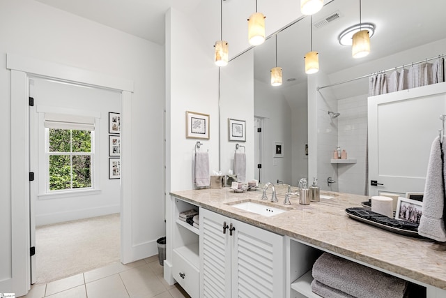 full bathroom with tile patterned floors, vanity, baseboards, visible vents, and tiled shower