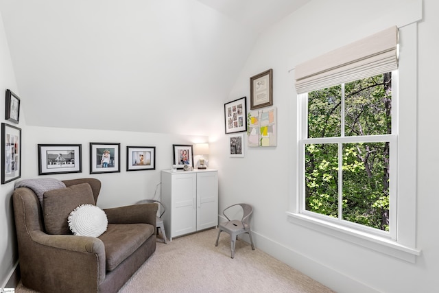 sitting room with lofted ceiling, plenty of natural light, baseboards, and light colored carpet