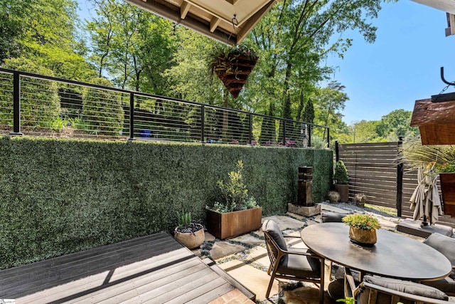 wooden terrace with a patio area, outdoor dining area, and a fenced backyard
