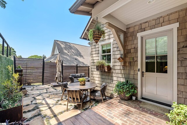 view of patio / terrace with fence, a wooden deck, and outdoor dining area