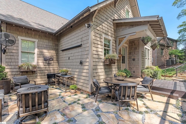view of patio / terrace with central air condition unit, outdoor dining space, and an outdoor fire pit