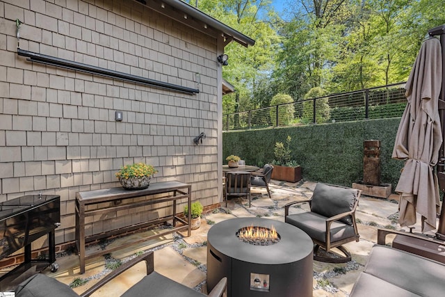 view of patio / terrace with fence and an outdoor living space with a fire pit