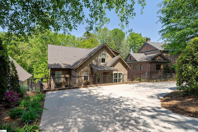 view of front facade with a gate, driveway, and fence