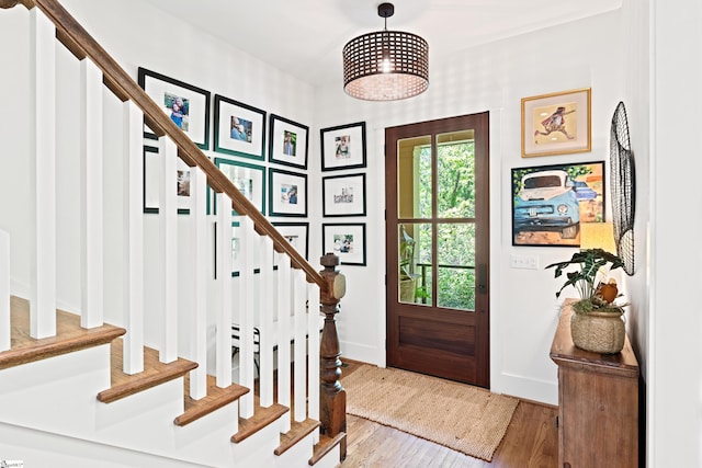 foyer entrance featuring baseboards, wood finished floors, and stairs