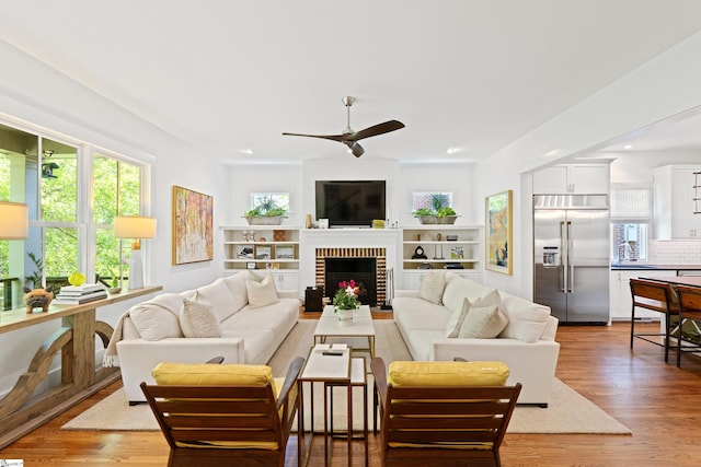 living room with wood finished floors, a wealth of natural light, and a ceiling fan