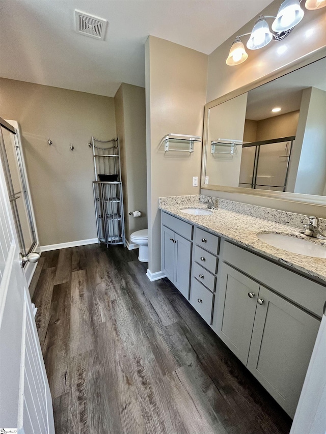 full bath featuring wood finished floors, visible vents, toilet, a sink, and a stall shower