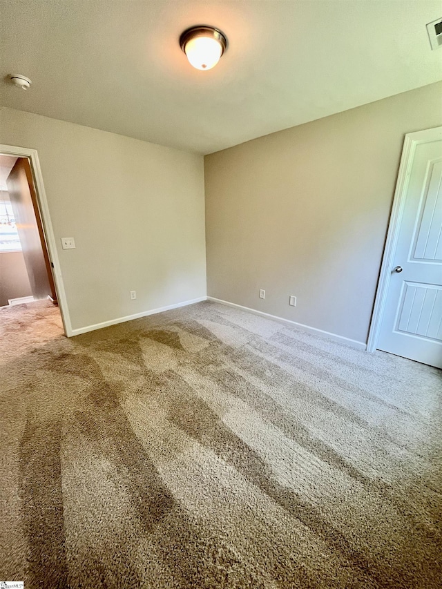 carpeted empty room featuring visible vents and baseboards