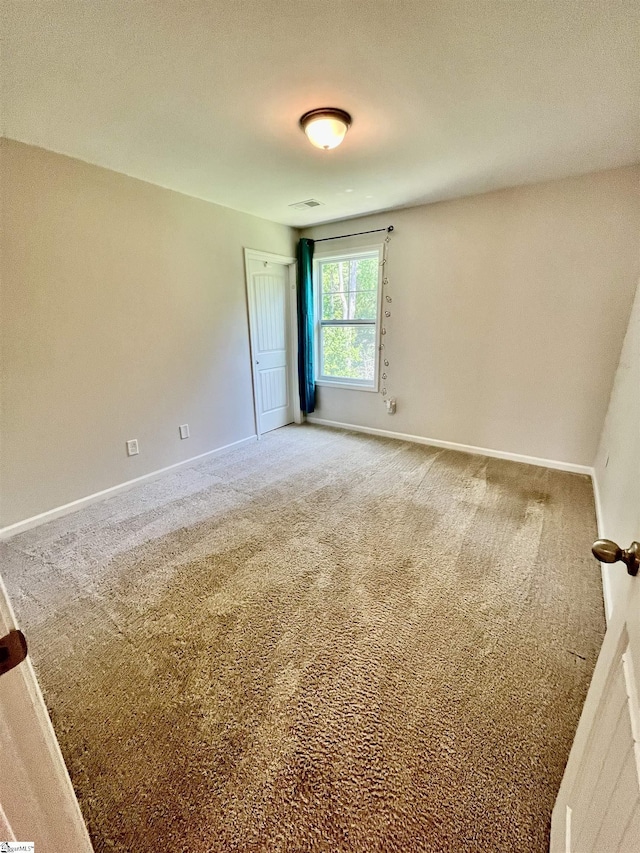 unfurnished room featuring visible vents, baseboards, and carpet