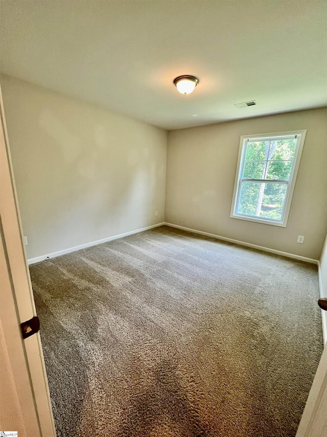 unfurnished room featuring carpet, visible vents, and baseboards