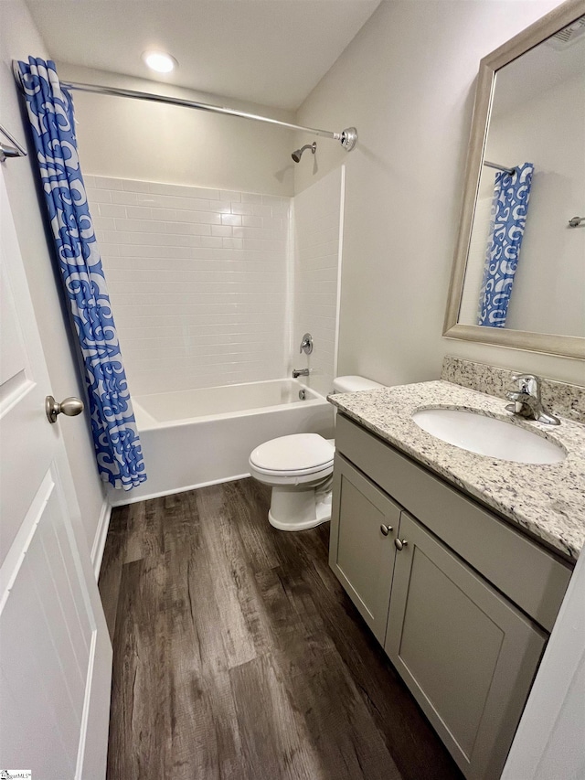 bathroom featuring toilet, vanity, wood finished floors, and shower / bath combo with shower curtain