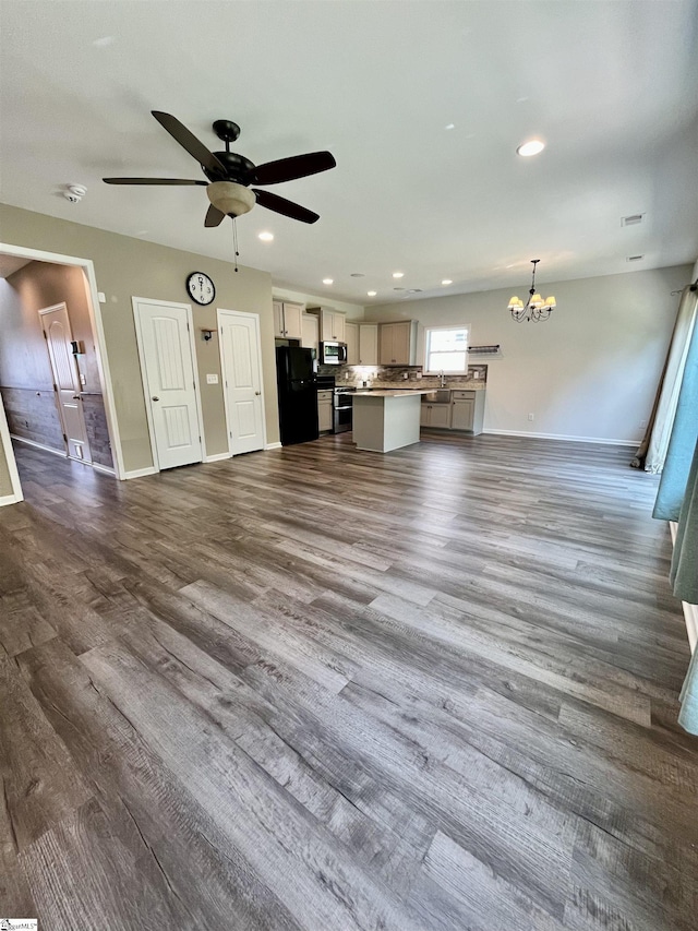 unfurnished living room with a sink, baseboards, recessed lighting, ceiling fan with notable chandelier, and dark wood-type flooring