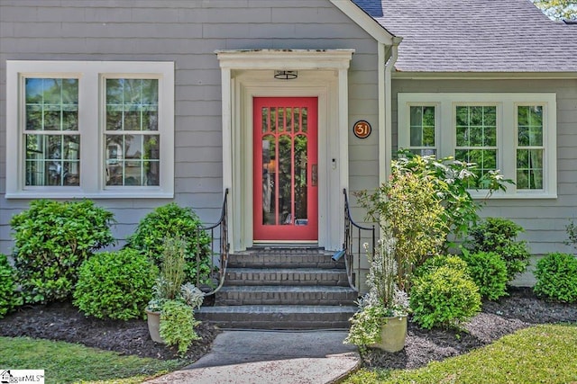 entrance to property featuring a shingled roof