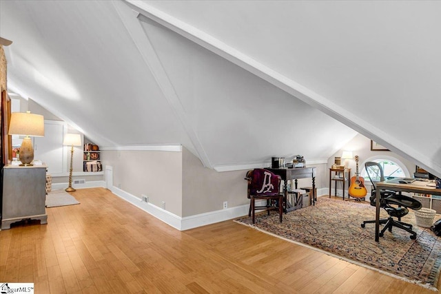 office featuring lofted ceiling with beams, baseboards, wood finished floors, and visible vents