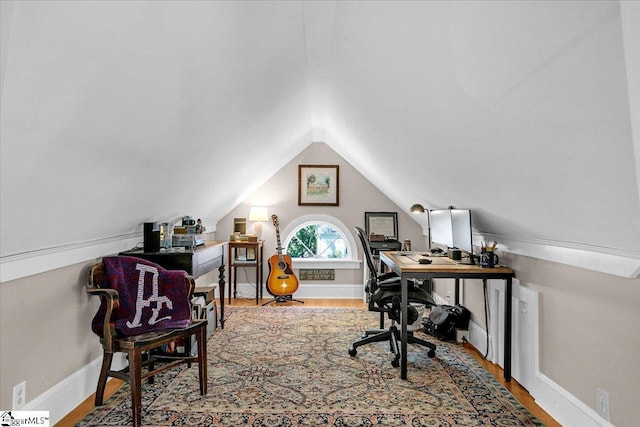 office area featuring vaulted ceiling, baseboards, and wood finished floors