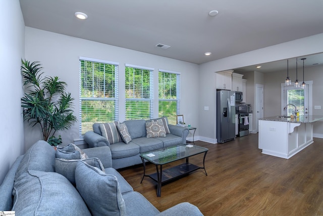 living room featuring baseboards, visible vents, recessed lighting, and dark wood finished floors