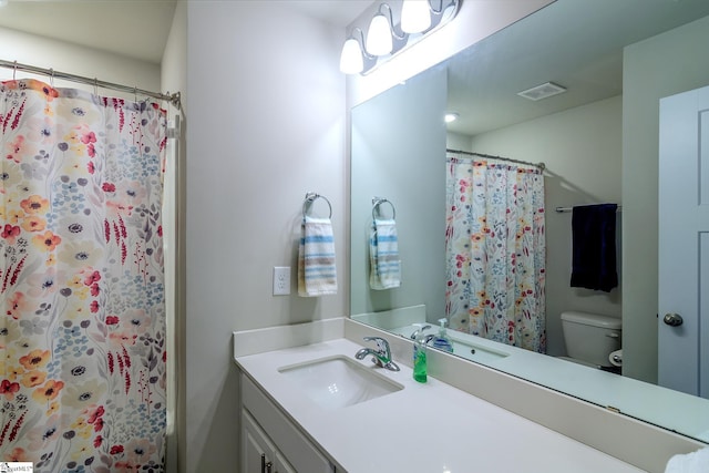 bathroom featuring visible vents, toilet, and vanity