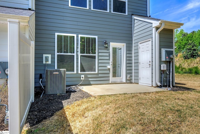 back of property with cooling unit, a lawn, and a patio