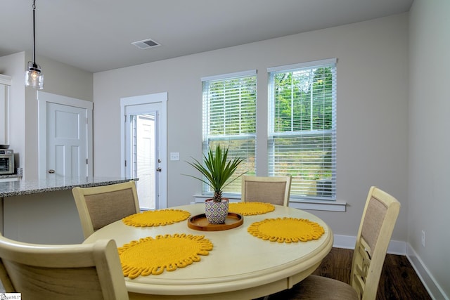 dining space featuring baseboards, dark wood-style flooring, and visible vents