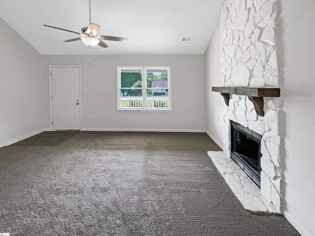 unfurnished living room featuring carpet flooring, a stone fireplace, visible vents, and ceiling fan