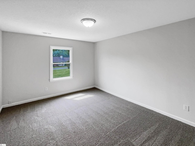 carpeted empty room featuring baseboards and visible vents