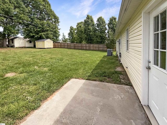 view of yard with central AC, an outdoor structure, fence, a patio, and a storage unit