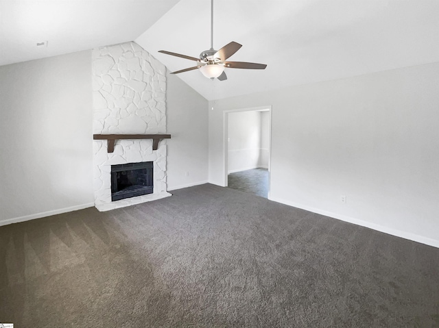unfurnished living room featuring baseboards, lofted ceiling, dark carpet, ceiling fan, and a stone fireplace